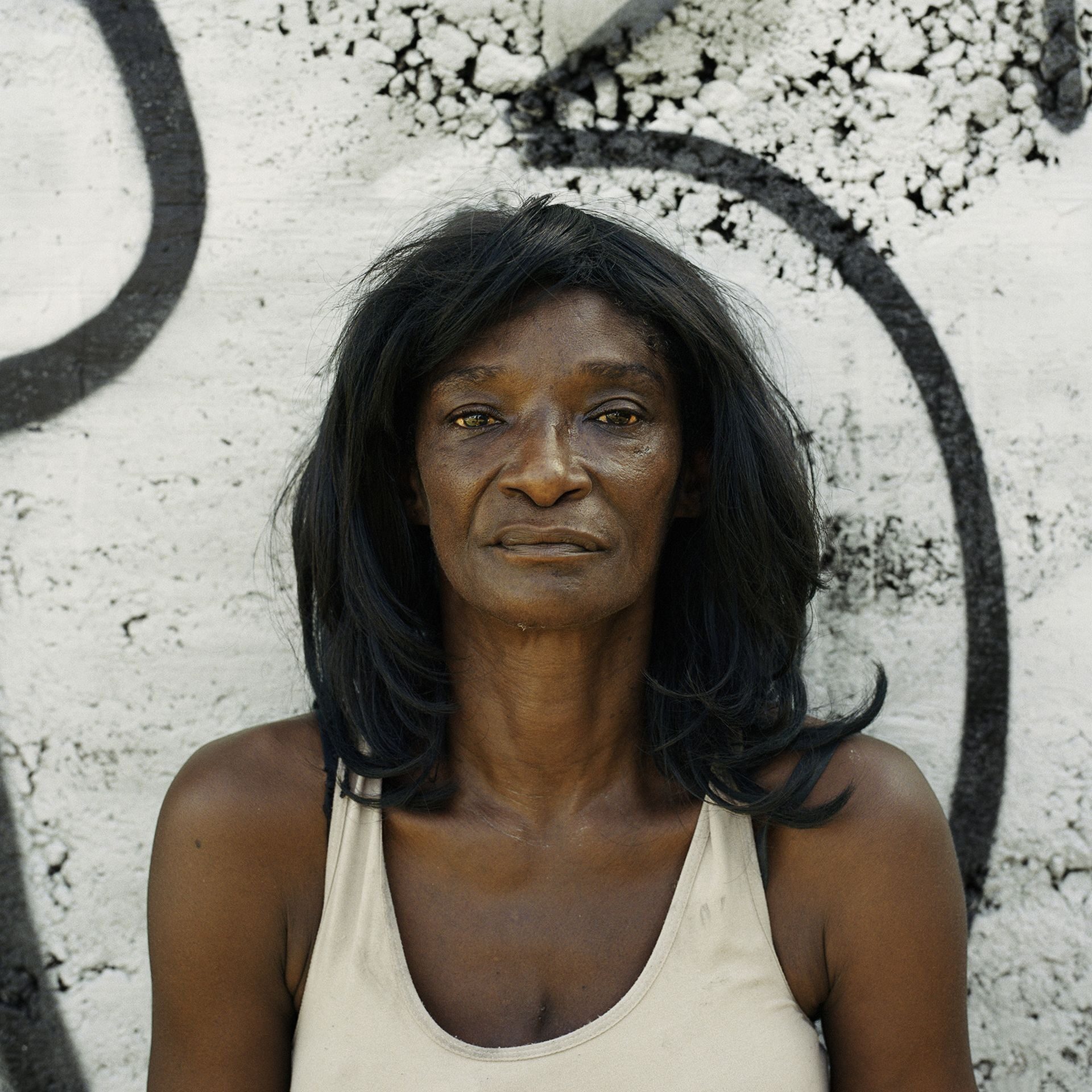 African woman with long hair and white tank top
