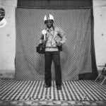 Autoportrait de S. sory avec un casque de moto sur la tête dans son studio photo