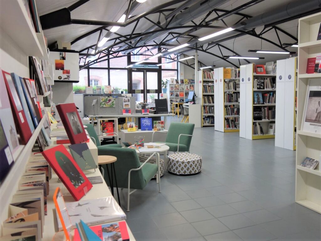 View of the library entrance with book displays, lounge area and shelving