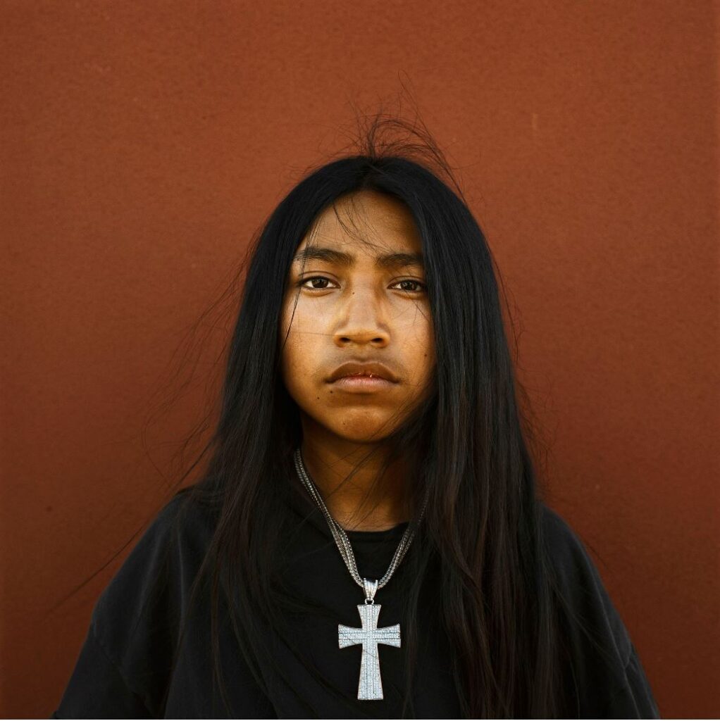 Jeune indien aux cheveux longs portant une croix autour du coup