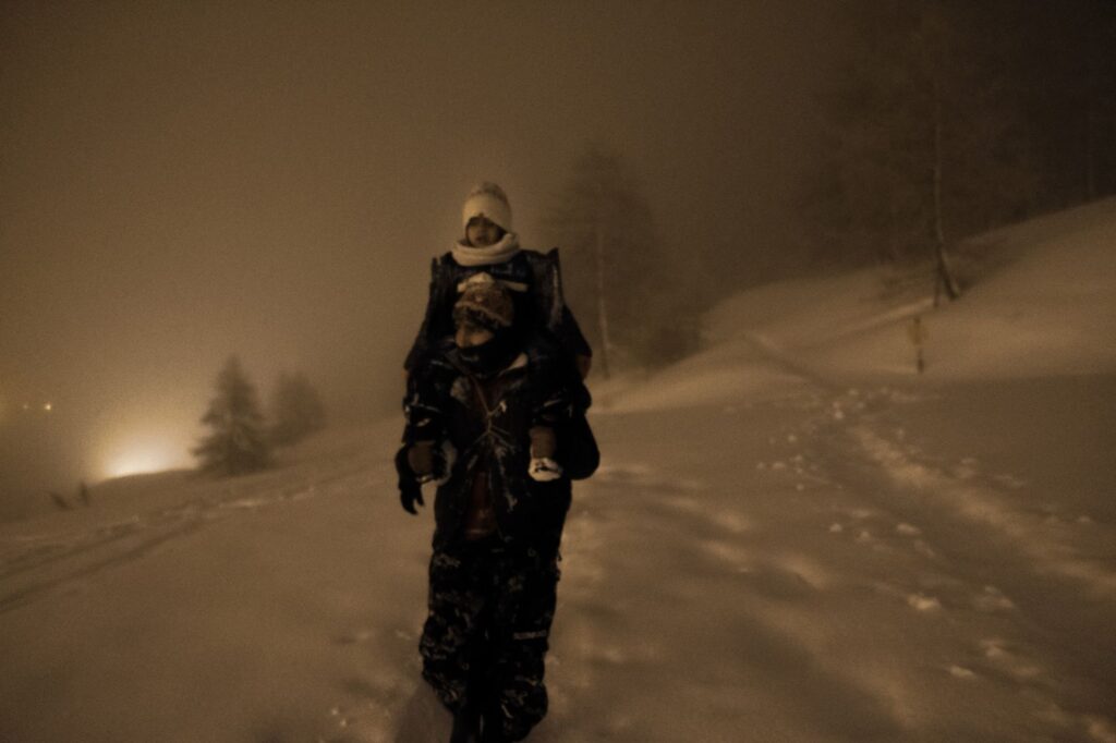 photographie de Sinawi Medine montrant un homme seul marchant la nuit dans la neige.