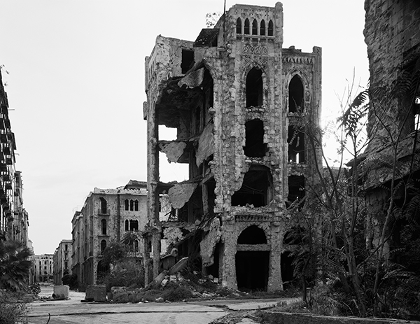 B/W photograph of a street in Beirut showing a destroyed building in the foreground.